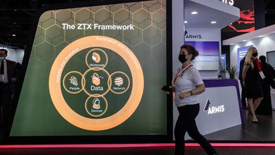 A visitor walks past the Armis Security stand.