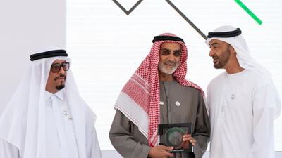 Sheikh Mohamed bin Zayed, Crown Prince of Abu Dhabi and Deputy Supreme Commander of the UAE Armed Forces (right), presents an award for founder and chairman of the family council Ali bin Khalfan AL Dhaheri, on behalf of Ali & Sons Holding for participating in Sandooq Al Watan, during a Sea Palace barza. Seen with Lt General Dhahi Khalfan Tamim, Chairman of the Board of Directors at Sandooq Al Watan (left). Rashed Al Mansoori / Ministry of Presidential Affairs