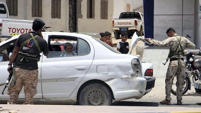 Yemeni security forces inspect vehicles at a checkpoint in Mukalla on July 19, 2016, weeks after driving Al Qaeda from the southern port city as part of a continuing operation by the Saudi-led coalition and Yemeni forces against the extremist group. Abduljabbar Bajubair / AFP