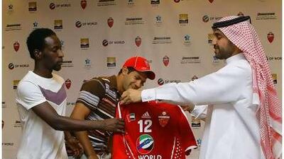 Hosny Abd Rabo, centre, is welcomed by the Al Ahli club chairman Khalifa Saeed Suleiman, right, and the captain Salem Khamis. Jeffrey E. Biteng / The National