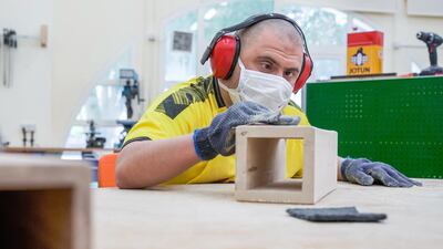 Saif Helal busily sands a wooden piece at the workshop