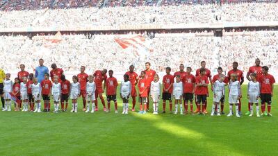 Bayern Munich players stand with refugee children on the pitch prior to the Bundesliga match against Augsburg on Saturday. Kerstin Joensson / AP / September 12, 2015