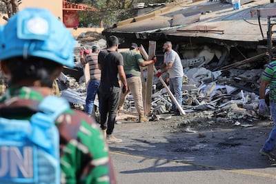A Unifil soldier look on as workers remove the rubble from a site targeted by an Israeli air strike in Et Taybeh, southern Lebanon. AFP