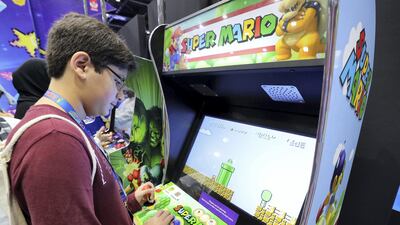 Dubai, United Arab Emirates - April 11, 2019: Visitors play on old arcade games at the Middle East Film and Comic Con. Thursday the 11th of April 2019. World Trade Centre, Dubai. Chris Whiteoak / The National
