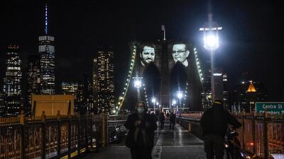 Images of New Yorkers lost in the Covid-19 pandemic are projected on the Brooklyn Bridge, March 14, 2021. Getty Images/AFP