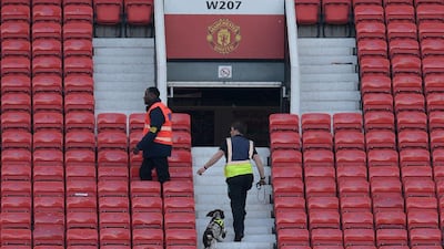 A sniffer dog searches the stands at Old Trafford in Manchester, north west England, on May 15, 2016, after the Premier League match between Manchester United and Bournemouth was abandoned. Half of the stands at Manchester United’s Old Trafford were evacuated because of a suspicious package Sunday just ahead of their final Premier League game of the season against Bournemouth. Oli Scarff / AFP