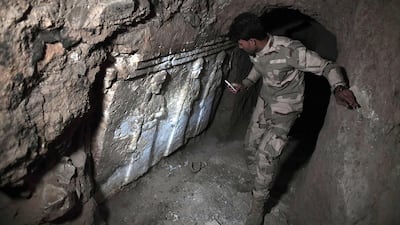 A member of the Iraqi troops stands next to archeological findings inside an underground tunnel in east Mosul on March 6, 2017. Two winged bulls dating from the Assyrians empire were found in a labyrinth of narrow underground tunnels dug by ISIL in east Mosul. Aris Messinis/AFP