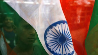 A boy's face is seen through the Indian national flag in Mumbai. Reuters