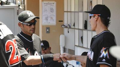 Ichiro Suzuki of the Miami Marlins bumps fists with Derek Dietrich in the dugout after hitting a single during the first inning of a baseball game against the San Diego Padres at Petco Park on June 15, 2016 in San Diego, California. Denis Poroy/Getty Images/AFP