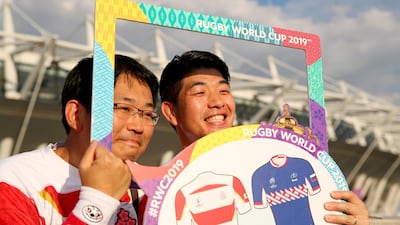 Japan fans pose for a photo outside the stadium. Getty Images