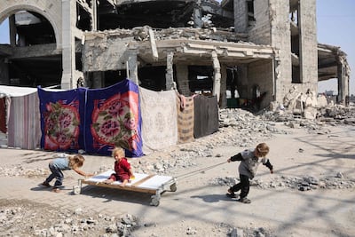 Palestinian children play outside the damaged Imam al Shafi Mosque in Gaza city. AFP