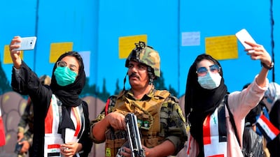 Students pose for selfies with a member of the security forces during ongoing anti-government protests in Diwaniyah. AFP