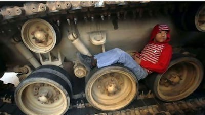 Advocacy groups are concerned that, after the political upheaval and violence in Eygpt, the physical and emotional scars on children could have devastating effects. Above, a boy sits on the tracks of a tank in Cairo.