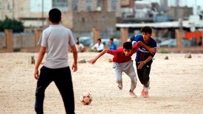 Yemeni youth take part in a football match in their neighbourhood in the capital Sanaa on April 11, 2018. A shock winning streak has propelled Yemen's youth and men's football teams to the Asian Cup, capturing the beleaguered nation's attention and offering a common goal to a divided country. The qualification is a first ever for the senior team, currently based in Qatar, and a rare achievement for the under-16s who still train in Yemen. / AFP PHOTO / MOHAMMED HUWAIS
