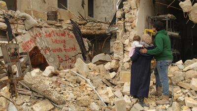 Waad Al-Kateab, her husband, Hamza and their daughter, Sama, review the words they painted on a bombed-out building. Courtesy Waad al-Kateab