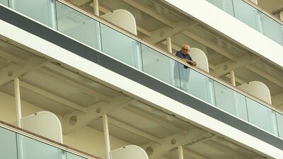 A passenger watches Emirati men perform a traditional dance from the Seabourn Encore ship. Christopher Pike / The National