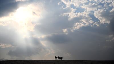 Tourists ride camels in the desert of the Sealine Beach area in Doha, Qatar. EPA