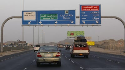 Vehicles heading to the Muslim holy city of Mecca pass under a street sign that directs Muslims towards Mecca and non-Muslims, who are not allowed entry to Mecca, to other destinations, on the motorway between Jeddah and Mecca, Saudi Arabia. AP Photo / Amr Nabil