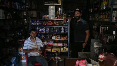 A vendor smokes a Hookah inside his shop without electricity in Beirut, Lebanon, on August 10, 2021. EPA