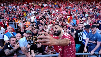 Mohamed Salah takes a selfie with fans at Anfield. PA