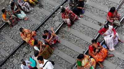 People sit on railway tracks in Kolkata. Rupak De Chowdhuri / Reuters
