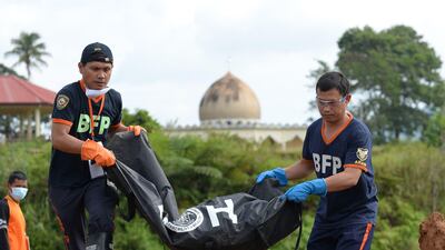 Rescuers carry a body bag containing the remains of a victim of the fighting in Marawi during a mass burial at a public cemetery in the city on July 24, 2017. Ted Aljibe / AFP