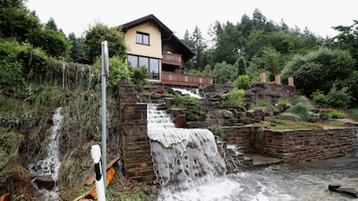 Floodwaters flow from the garden of a house in Schuld, Germany.