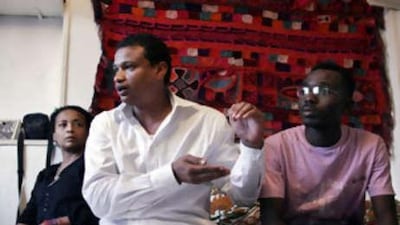 Ammar Nagm al Din Hussein, centre, from Khartoum, talks about Omar al Bashir in Cairo while Yasmine Hakem, left, and Mohammed al Haqqar, from Darfur, listen.