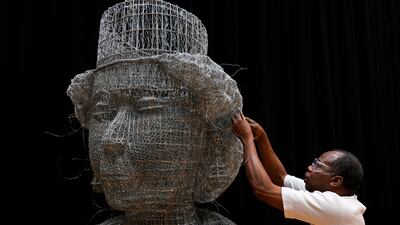 Artist Carl Gabriel works on a sculpture made of wire depicting the head of Britain's Queen Elizabeth II. AP Photo