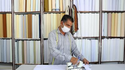 Ali Mousa from India irons kandouras at his Malabar tailoring shop on Kuwaiti shopping street in Ras Al Khaimah. Pawan Singh / The National