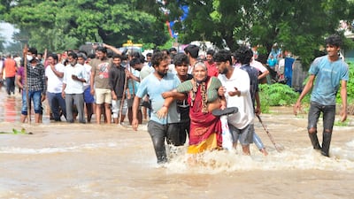 People wade through a flooded street in Nellore, India, on November 20. More than 20 people have died and dozens more are missing in the country's Andhra Pradesh state after days of heavy rains. Photo: AP