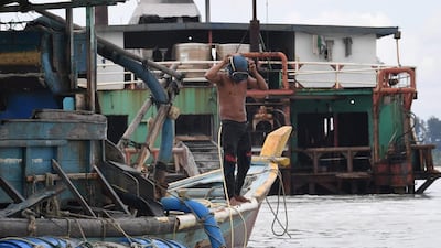 Illegal miner Paci adjusting his mask as he prepares for a dive to dredge tin from the seabed off Sungai Liat in northeast Bangka. One-third of the world's tin comes from the Indonesian islands of Bangka and Belitung, where thousands risk serious injury and death in the mines. Goh Chai Hin / AFP