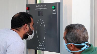 Egyptian people check their temperature at Cairo university after a repatriation flight from Kuwait in Giza, Egypt. EPA