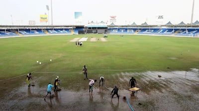 Ground staff try clearing the rain from the pitch at the Sharjah Cricket Stadium. The World Cup League 2 match between UAE vs Scotland was eventually abandoned. All photos by Pawan Singh / The National