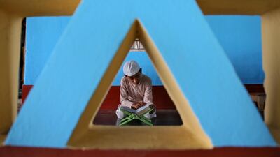 A Muslim boy reads the Quran inside a mosque on the first day of Ramadan on the outskirts of Agartala, India. Reuters