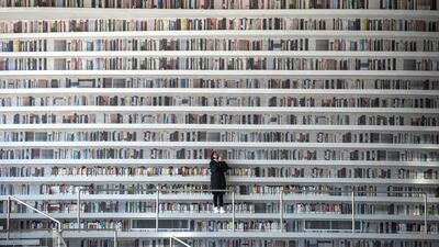 The Tianjin Binhai Library in China has wowed book lovers around the world with its white, undulating shelves rising from floor to ceiling, but if you read between the lines you'll spot one problem. Those rows upon rows of book spines are mostly images printed on the aluminium plates that make up the backs of shelves. Fred Dufour / AFP