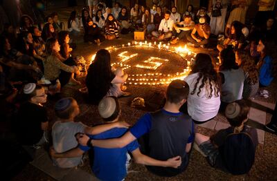 People gather around candles during a vigil in Tel Aviv on Mayv2, 2021 for the 45 ultra-Orthodox Jews killed in a stampede at a Lag BaOmer festival at Mount Meron. AP Photo