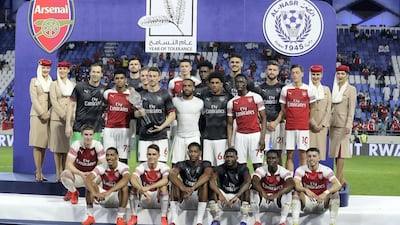 Arsenal players with the trophy after beating Al Nasr by 3-2 at the Al Maktoum stadium in Dubai. Pawan Singh / The National