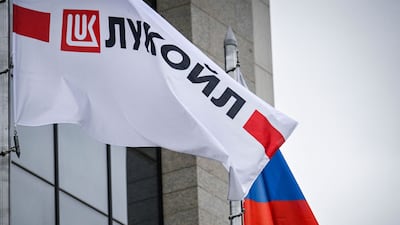 A Russian national flag and a Lukoil flag fly above the oil company's headquarters in Moscow. AFP