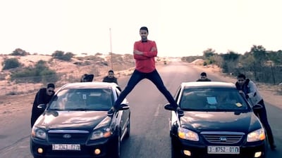 Video stills from the Tashwesh Comedy Troupe spoof of a Jean Claude Van Damme ad for Volvo show a man standing on two cars being pushed down a motorway by several other men. Courtesy Tashwesh Comedy Troupe