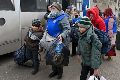 People prepare to board a bus to leave eastern Ukraine after Russian tanks and soldiers arrived in the Donetsk and Luhansk regions. (AP Photo)