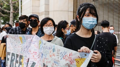 Supporters hold a banner to support pro-democracy activists as they queue up for a court hearing over the national security law outside West Kowloon Magistrates' Courts, in Hong Kong. Reuters