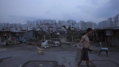 A resident walks outside his illegal rooftop hut, which is located next to a public housing estate. The US-based consultancy Demographia has ranked Hong Kong the world’s least affordable housing market for seven straight years.