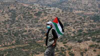 A demonstrator holding a Palestinian flag attends a protest against Jewish settlements, in the town of Biddy in the Israeli-occupied West Bank. Reuters