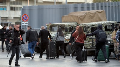 Passengers departing from Lebanon walk with their luggage to the airport due to a protest by supporters of Hezbollah. EPA