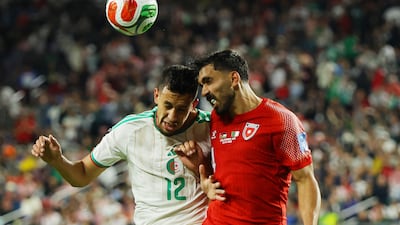 Jordan's Husam Abudahab, right, wins a header ahead of Algeria's Nadhir Benbouali. Reuters
