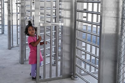 A child at a gate at the first of five new 'closed' migrant camps in Greece. AFP
