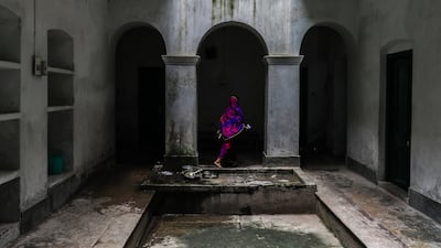 The daughter-in-law of Shivdayal Parasar, a resident aged 90, washes utensils at Kashi Labh Mukti Bhawan. EPA