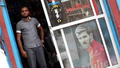 A barber waits for customers inside a shop decorated with posters of Argentine footballer Lionel Messi, in Sana'a, Yemen. EPA