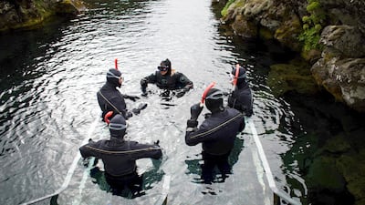 A diving instructor gives instructions before tourists plunge into the icy waters. Photo: Jeremie Richard / AFP